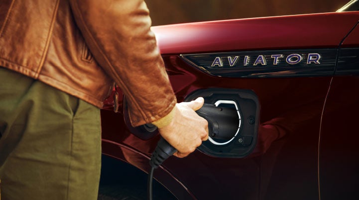 A hand is shown plugging in the charger into the charging port of a 2021 Lincoln Aviator | Cogswell Lincoln in Russellville AR