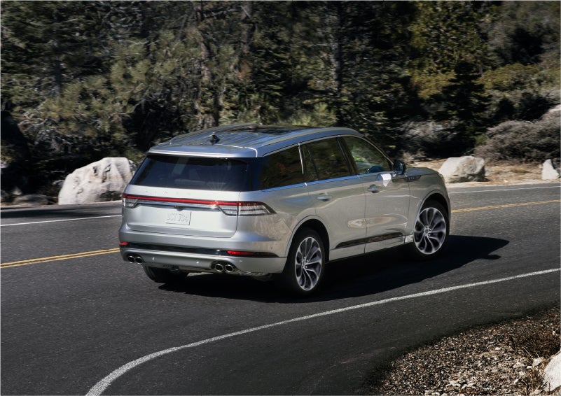 A 2023 Lincoln Aviator® Grand Touring model is shown being driven on a tight turn of a mountain road | Cogswell Lincoln in Russellville AR