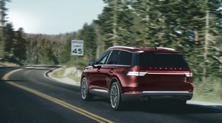 A 2024 Lincoln Aviator® SUV is being driven on a winding mountain road | Cogswell Lincoln in Russellville AR