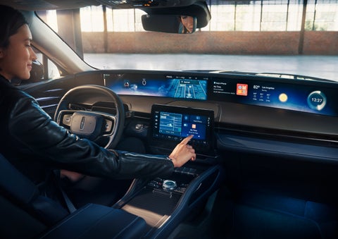 The driver of a 2024 Lincoln Nautilus® SUV interacts with the center touchscreen. | Cogswell Lincoln in Russellville AR